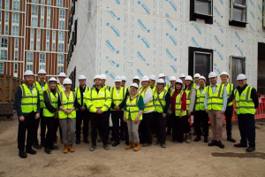 All visitors on the site having a group photo in front of the building