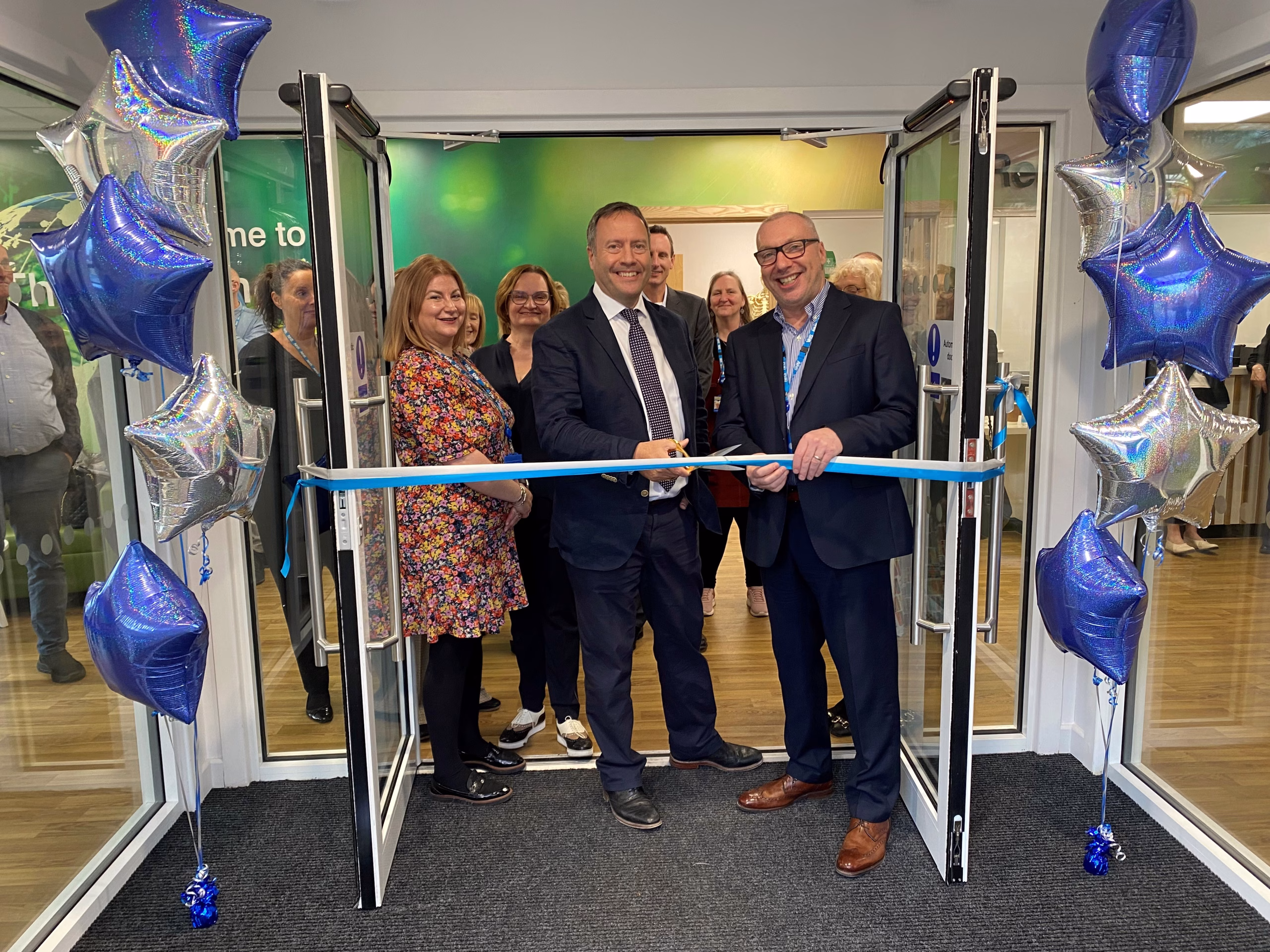 Calderdale Learning Centre opening ceremony - ribbon cutting with a group of people standing in the doorway of the new centre
